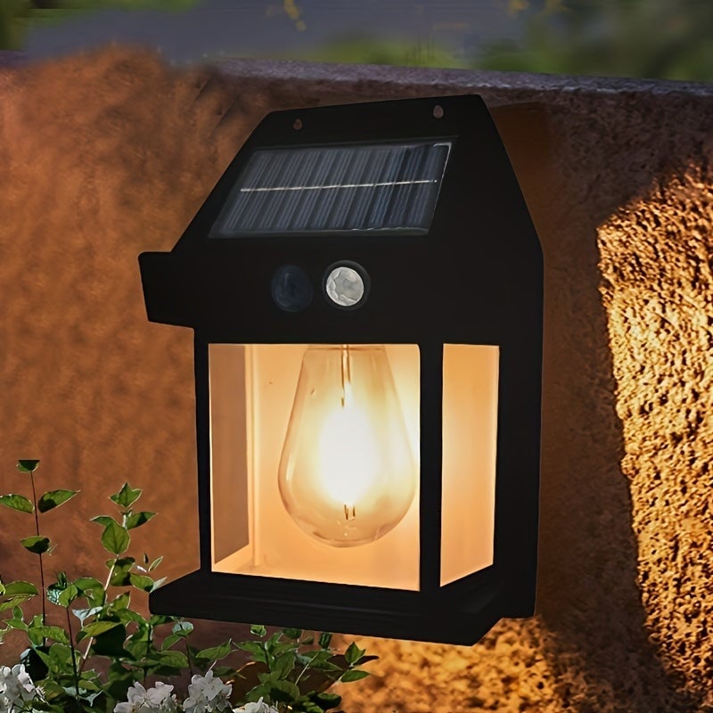 Lampa solară de perete montată pe gard, iluminând zona de acces în grădină.